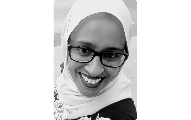 Black and white portrait of Capstone author, Siman Nuurali, smiling wide at the camera